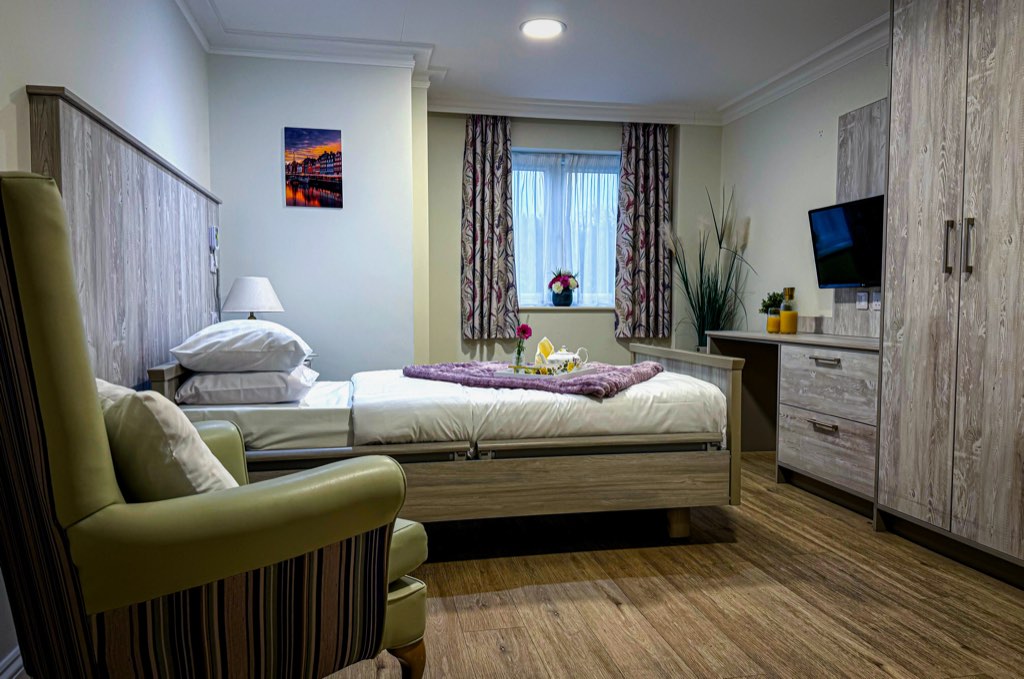Private en-suite bedroom with a comfortable armchair at Forest Place Nursing Home, Essex